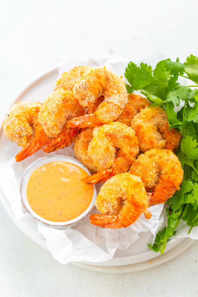 fried shrimp on a plate with dipping sauce