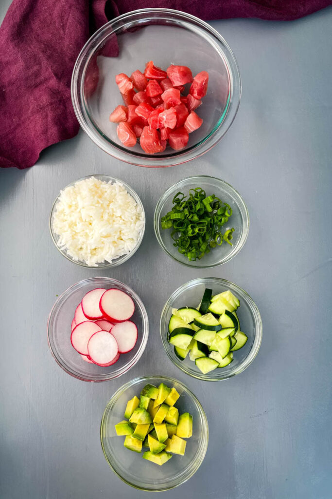 ahi tuna, radishes, cucumbers, rice, and avocado in separate bowls