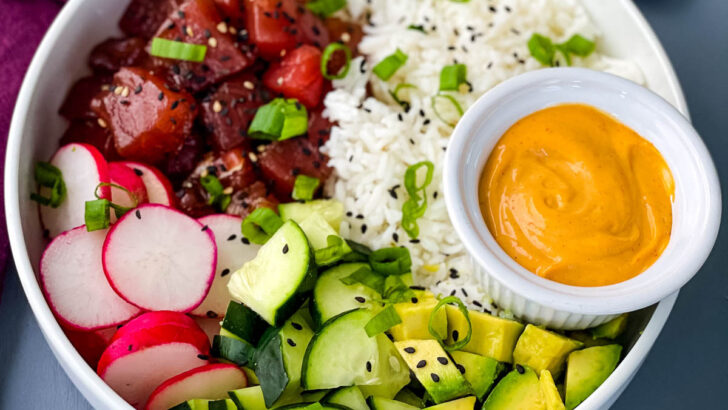 ahi tuna poke bowls with rice, avocado and spicy mayo sauce in a white bowl