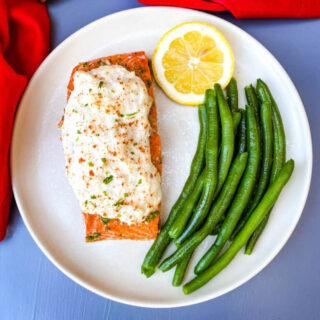 baked salmon stuffed with real crab meat on a plate with lemon and green beans