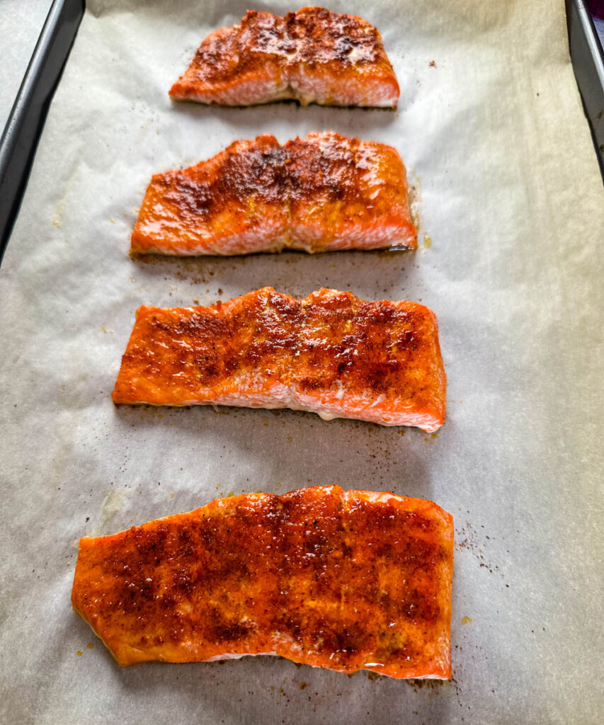 baked salmon on a sheet pan with parchment paper