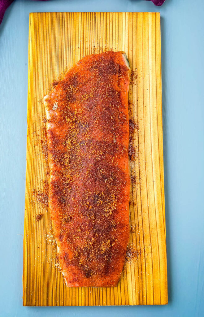 raw salmon on a cedar plank rubbed with spices and brown sugar