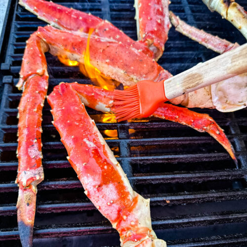king crab legs on a grill rubbed with butter
