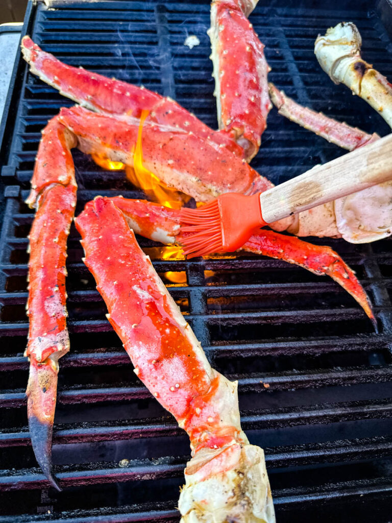 king crab legs on a grill rubbed with butter