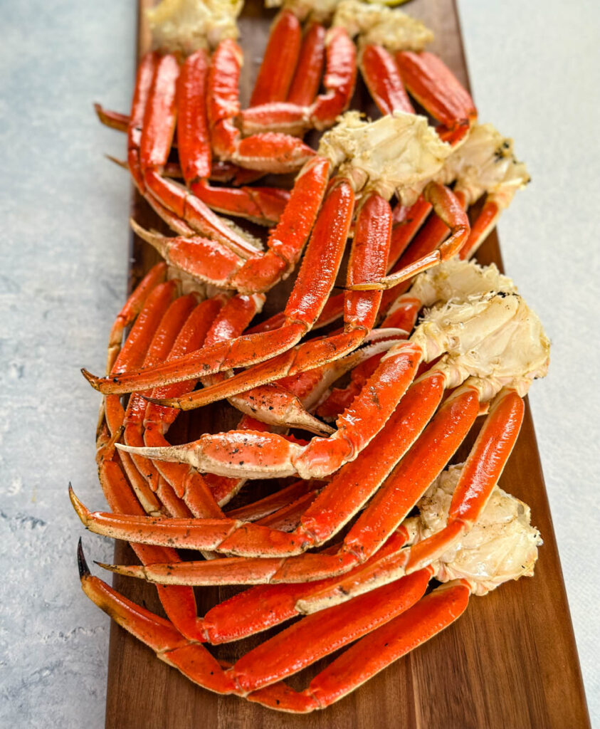 grilled snow crab legs on a wooden board with lemon