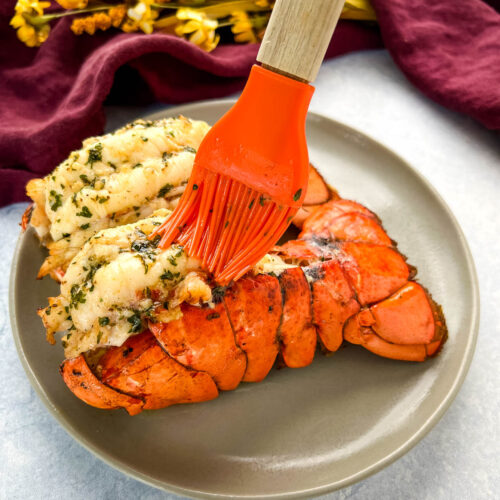 cooked butterflied lobster tail brushed with butter