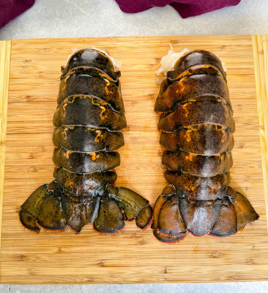 cold water lobster tails on a wooden cutting board
