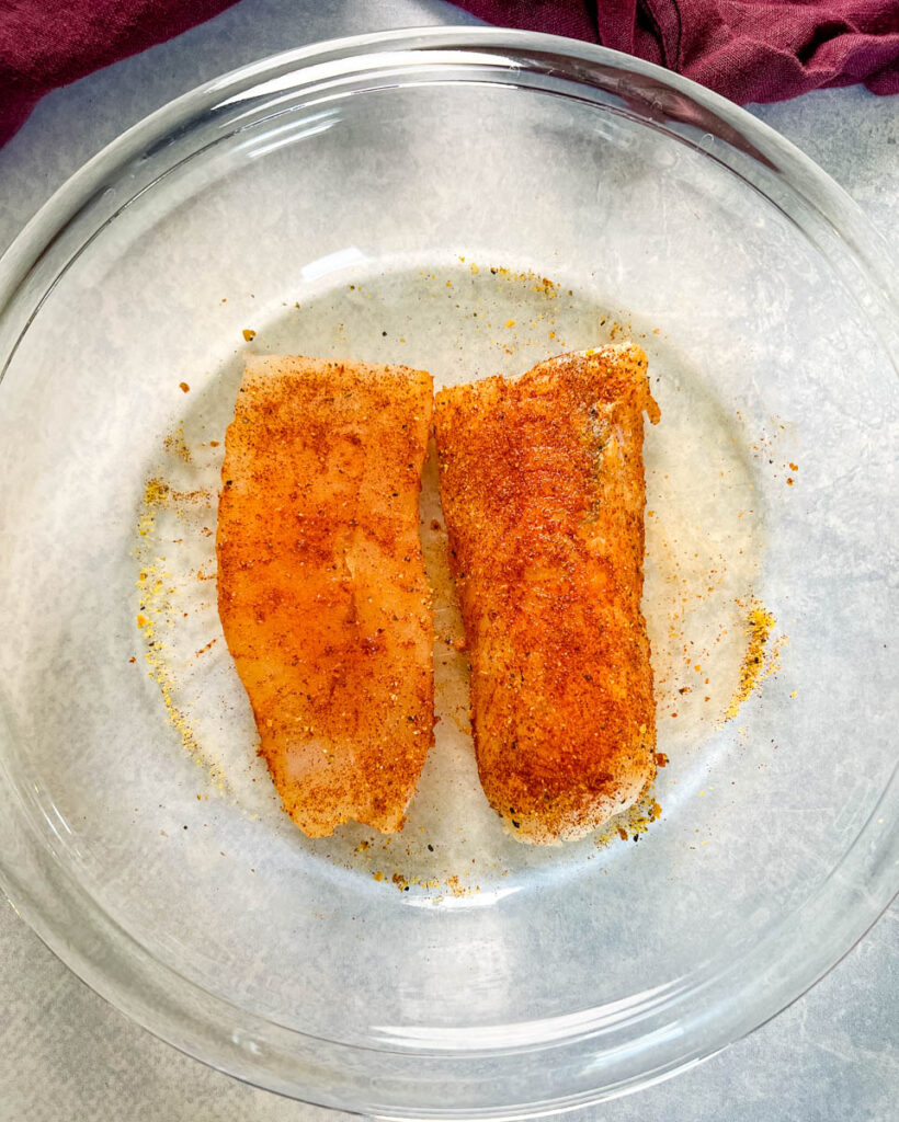 seasoned cod fillets in a glass dish