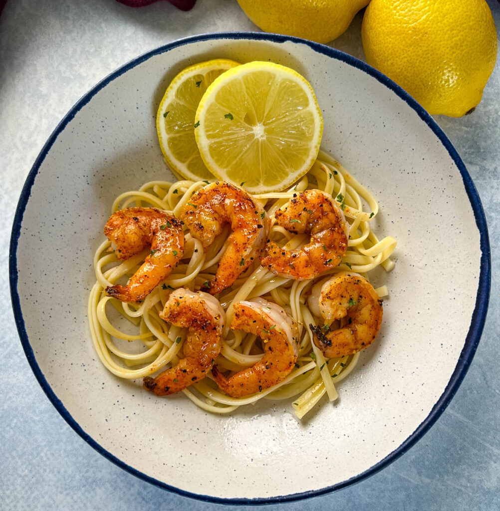 pan seared shrimp with lemon butter and pasta in a white bowl