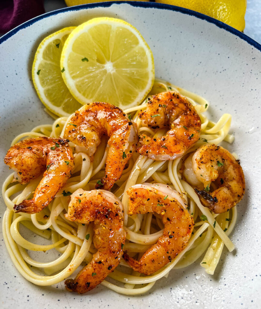 pan seared shrimp with lemon butter and pasta in a white bowl