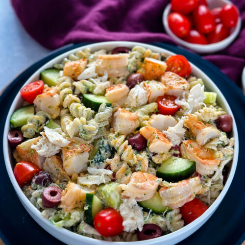 seafood pasta salad with shrimp and crab in a white bowl