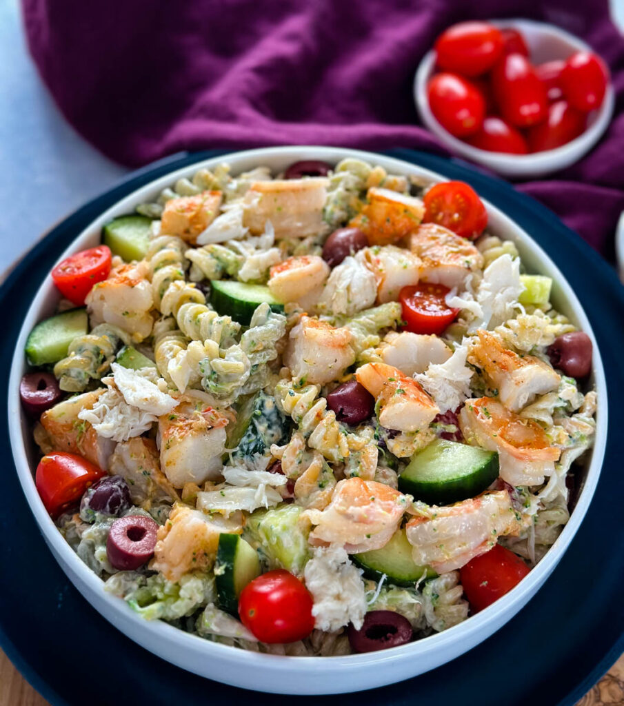 seafood pasta salad with shrimp and crab in a white bowl