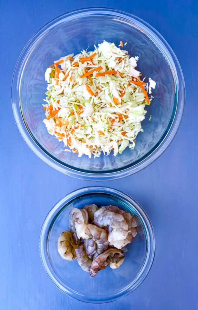 shredded cabbage, carrots, and shrimp in glass bowls