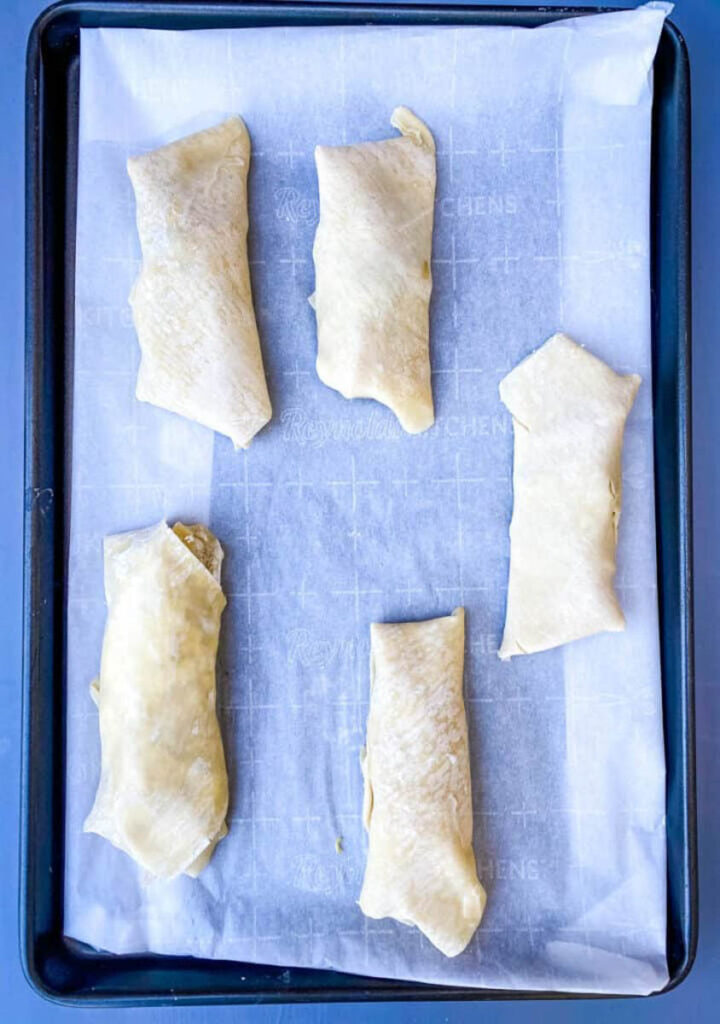 unbaked shrimp egg rolls on a sheet pan