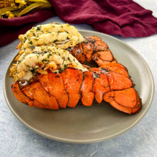 air fryer lobster tail on a plate with lemon garlic butter