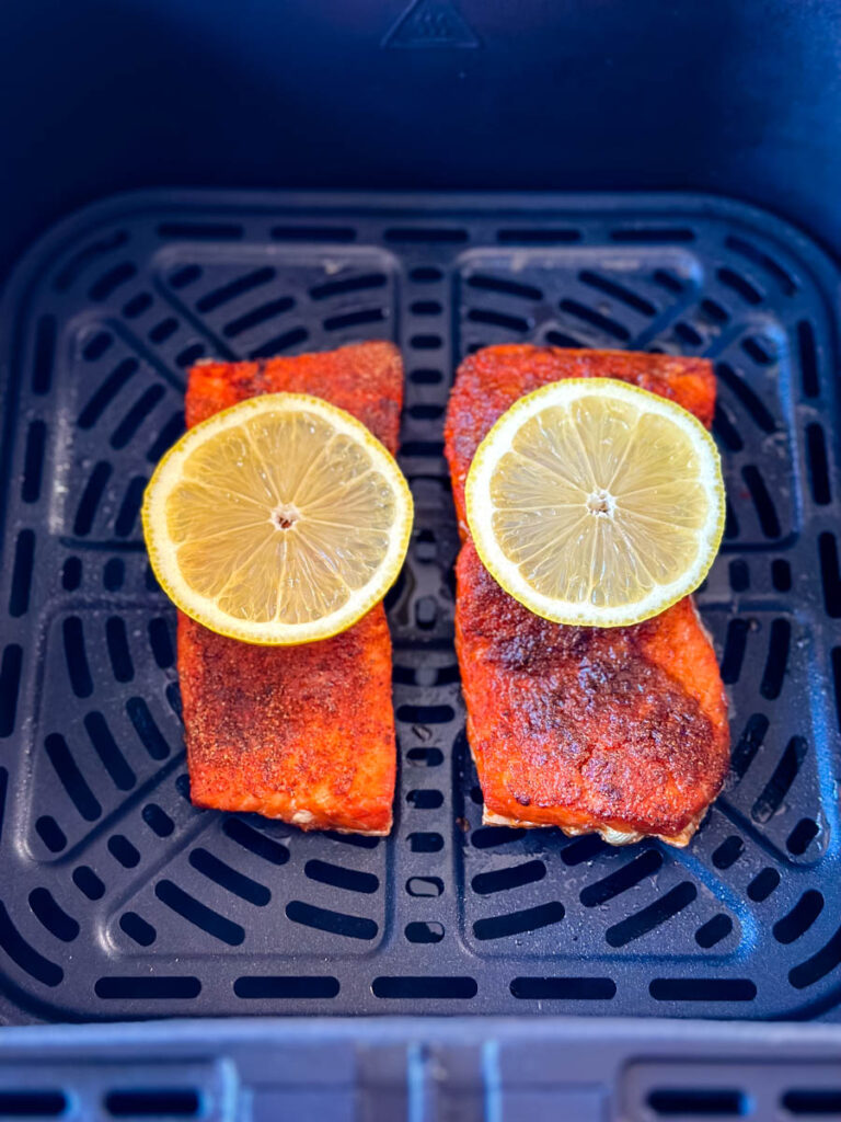 air fried salmon in air fryer with slices of lemon