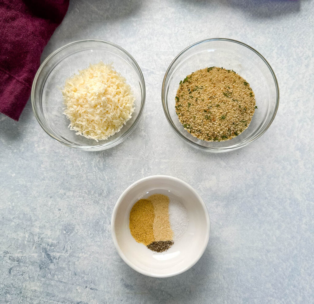 parmesan cheese, breadcrumbs, and spices in separate glass bowls