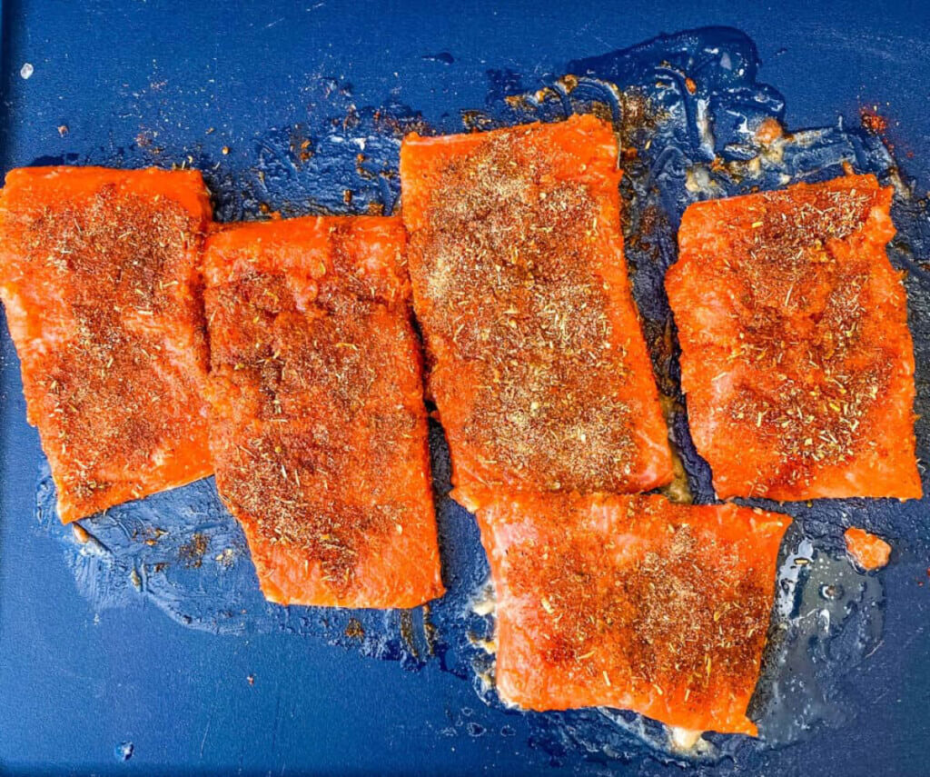 raw salmon with Cajun seasoning on a cutting board