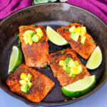 Cajun salmon in a cast iron skillet with mango and lime