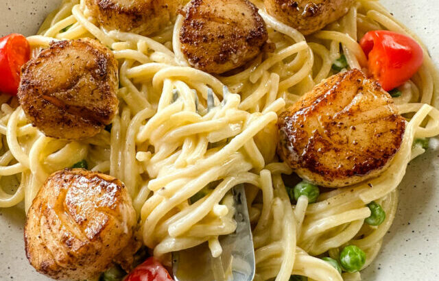 scallops and spaghetti pasta in white lemon cream sauce in a white bowl