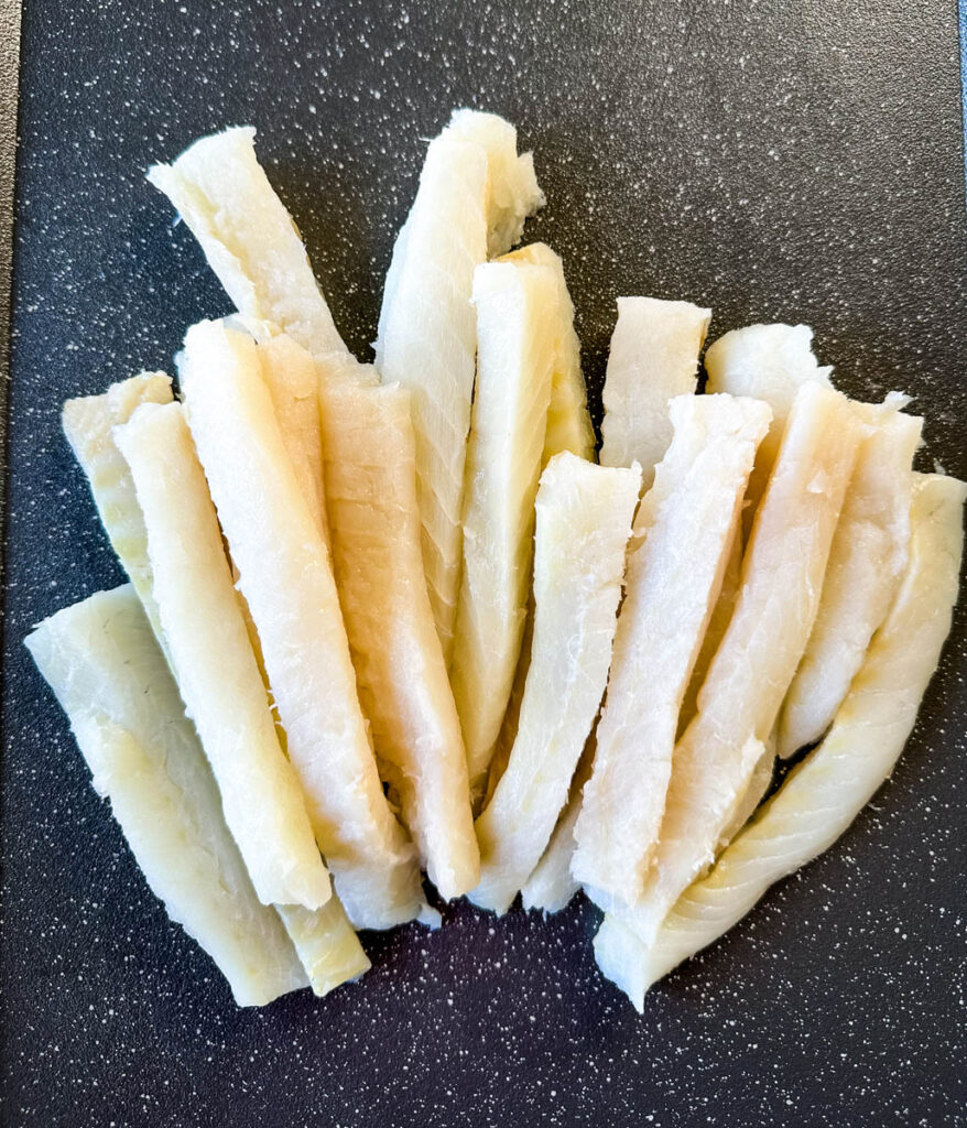 cod sliced into fish sticks on a sheet pan