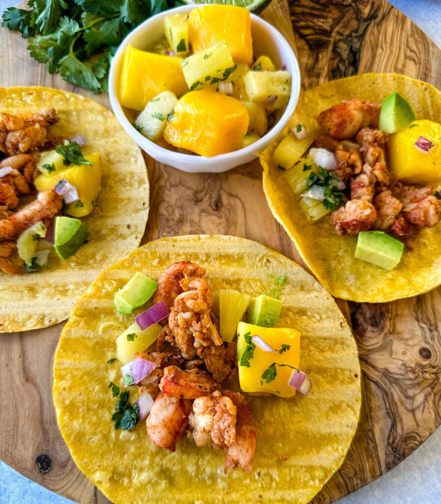lobster tacos with corn tortillas, avocado, and mango salsa