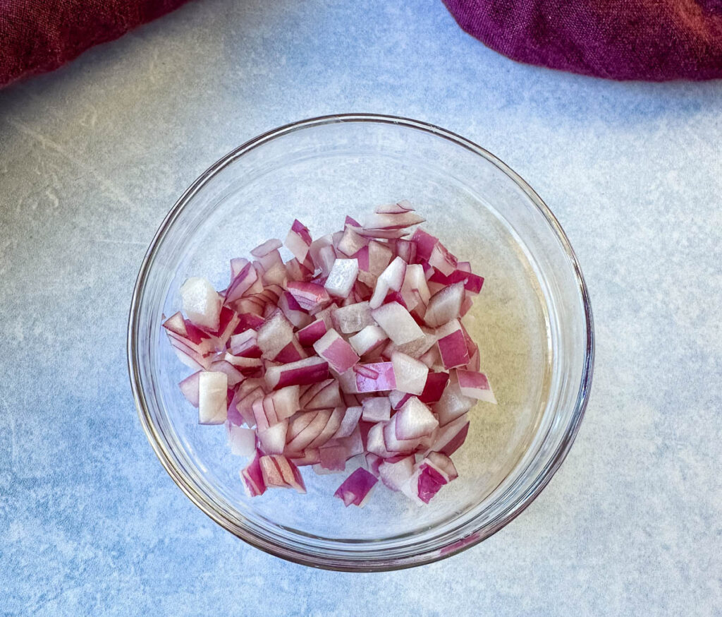 chopped red onions in a glass bowl