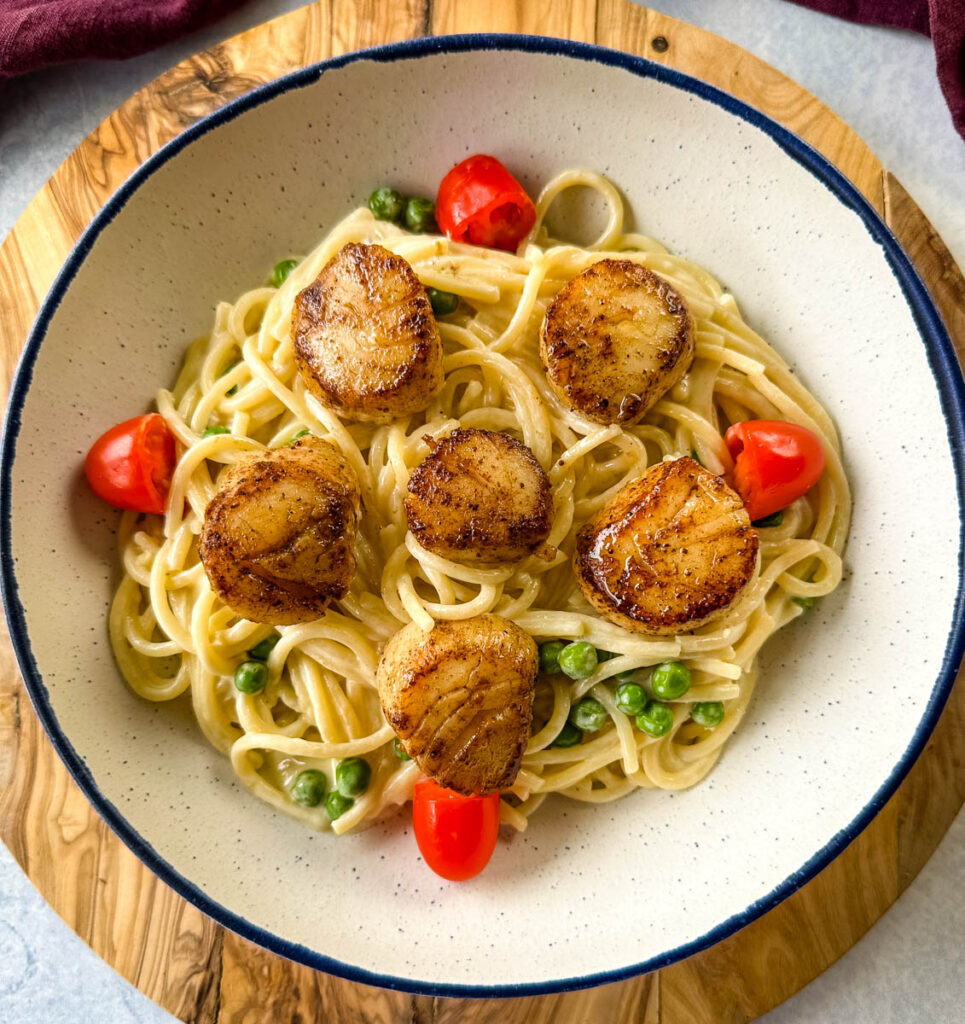 scallops and spaghetti pasta in white lemon cream sauce in a white bowl