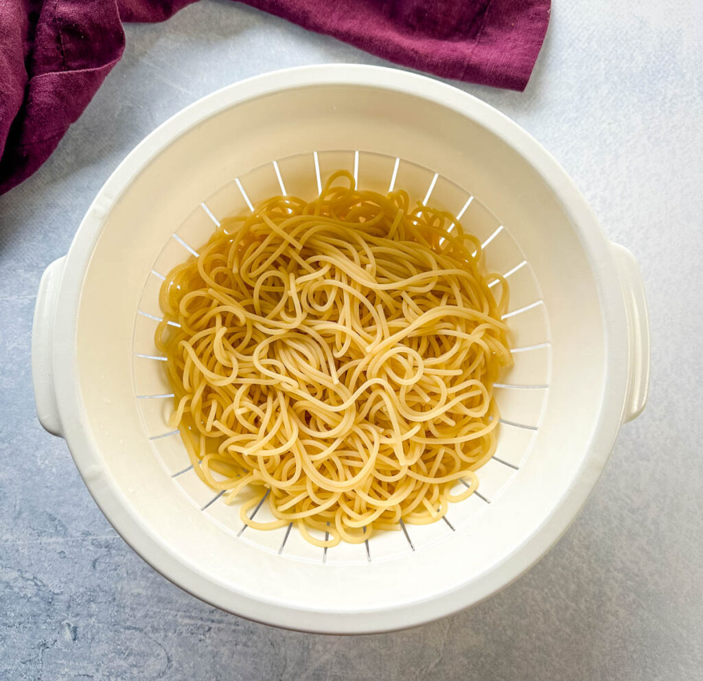 cooked spaghetti pasta in a white colander