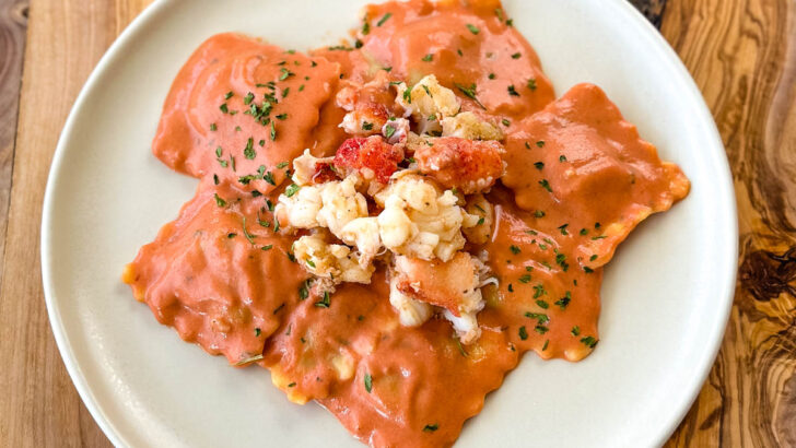 lobster ravioli with tomato cream sauce on a white plate