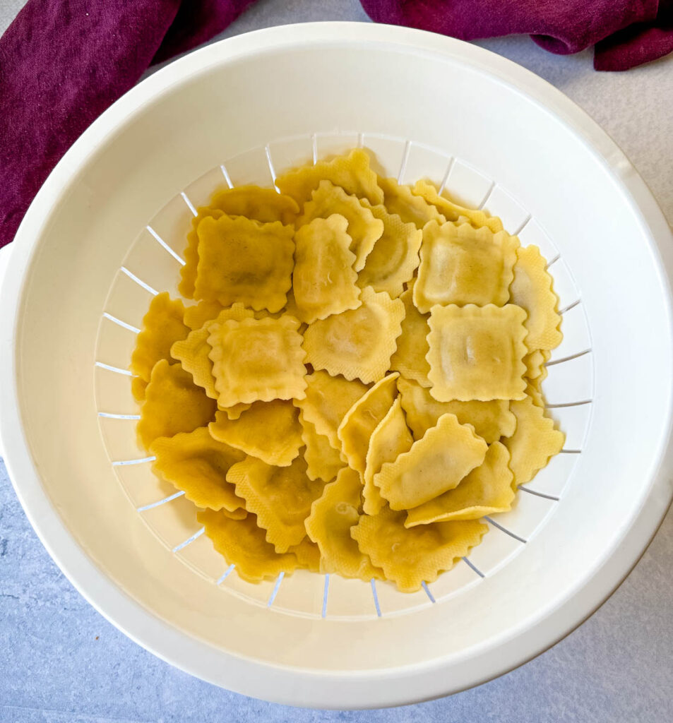 cooked ravioli in a white bowl