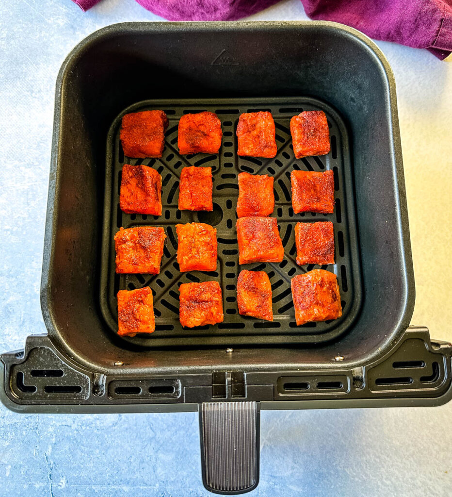 raw sliced salmon bites chunks in an air fryer