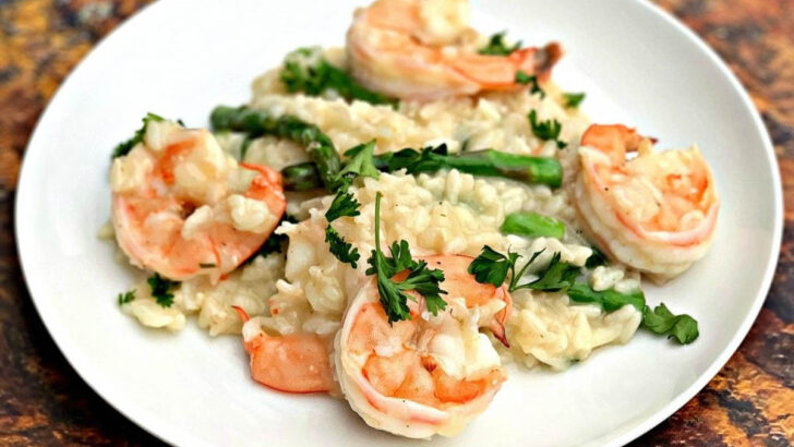 shrimp risotto with asparagus and spinach on a white plate