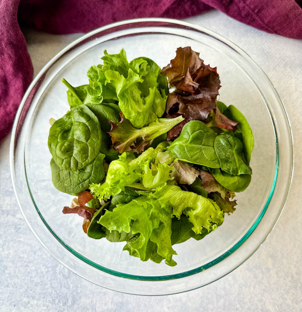 fresh salad greens in a glass bowl