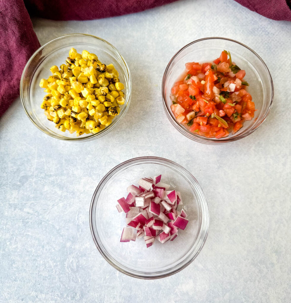 roasted corn, salsa, and chopped onions in separate glass bowls