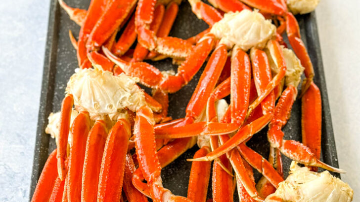 smoked crab legs on a sheet pan with smoky garlic butter