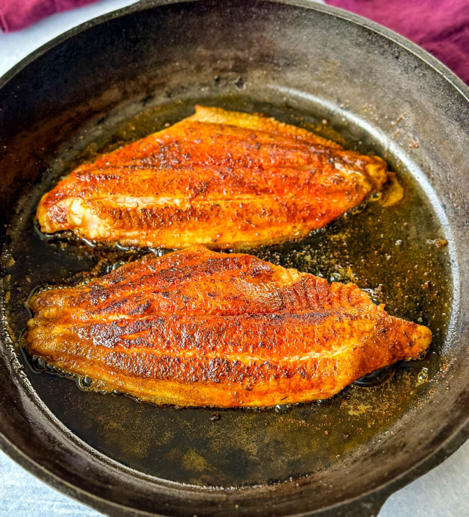 cooked blackened catfish in a cast iron skillet