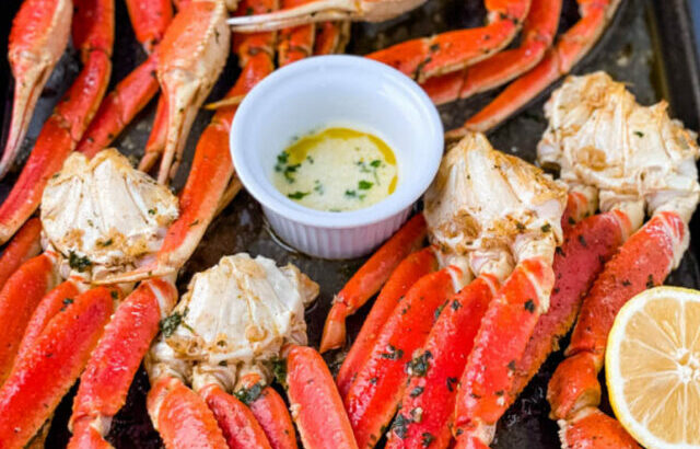 cooked crab legs on a plate with fresh lemon and butter