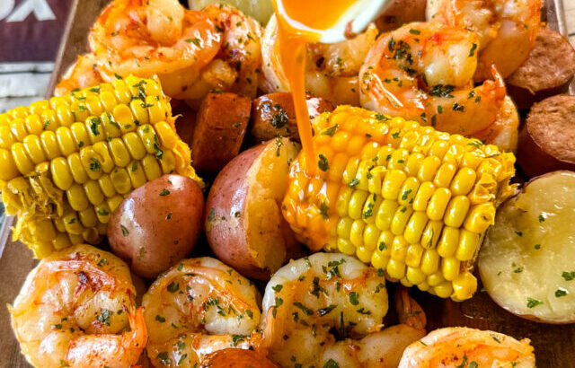 shrimp boil with andouille sausage, red potatoes, and corn on the cob drizzled with lemon butter sauce