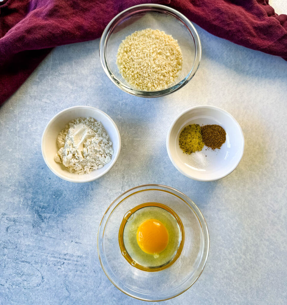 breadcrumbs, flour, spices, and egg in separate bowls