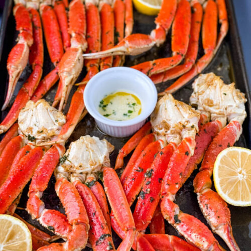 cooked crab legs on a plate with fresh lemon and butter