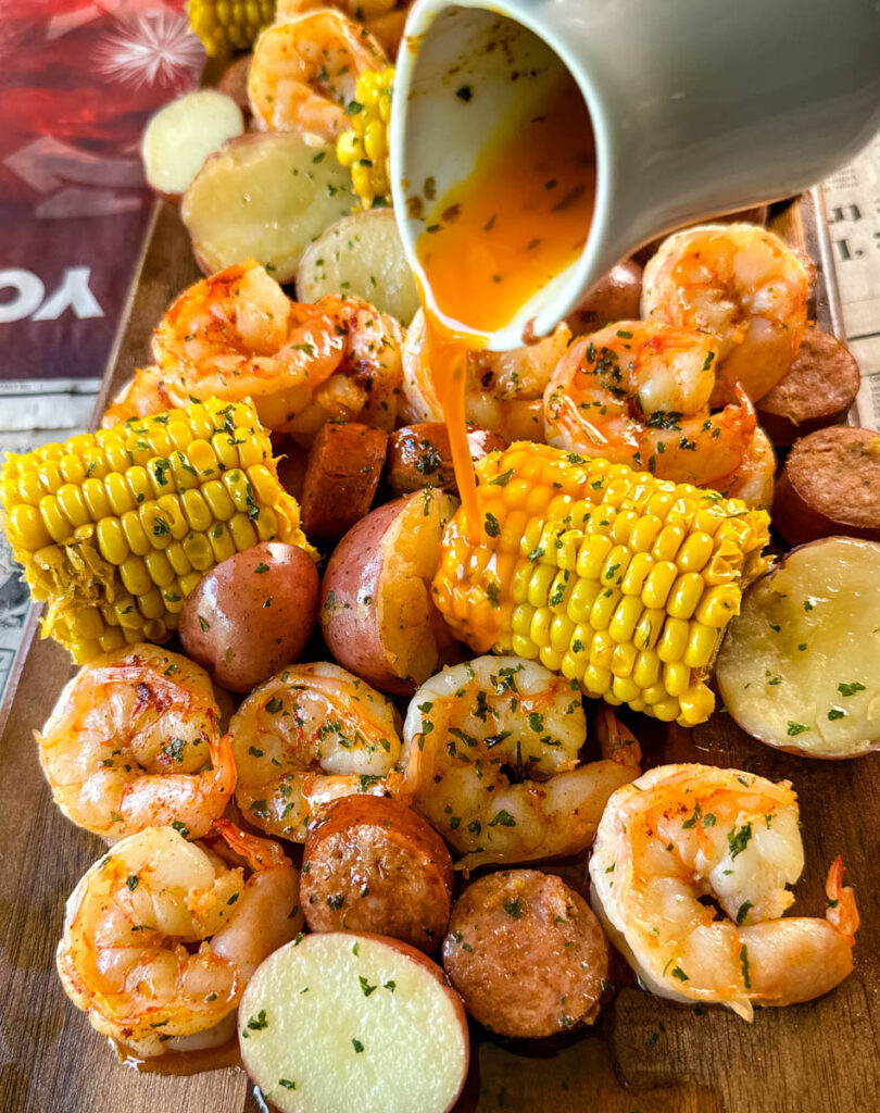 shrimp boil with andouille sausage, red potatoes, and corn on the cob drizzled with lemon butter sauce