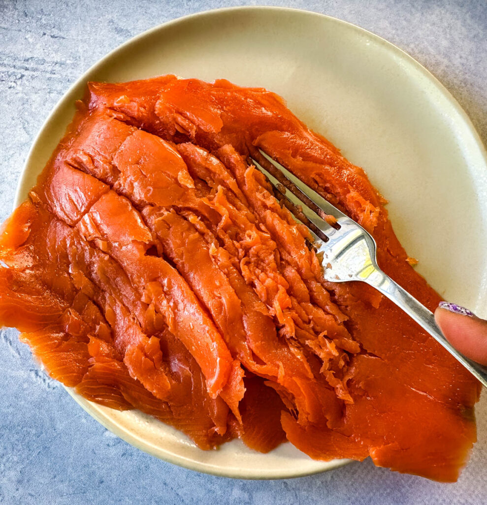 smoked salmon shredded with a fork on a plate