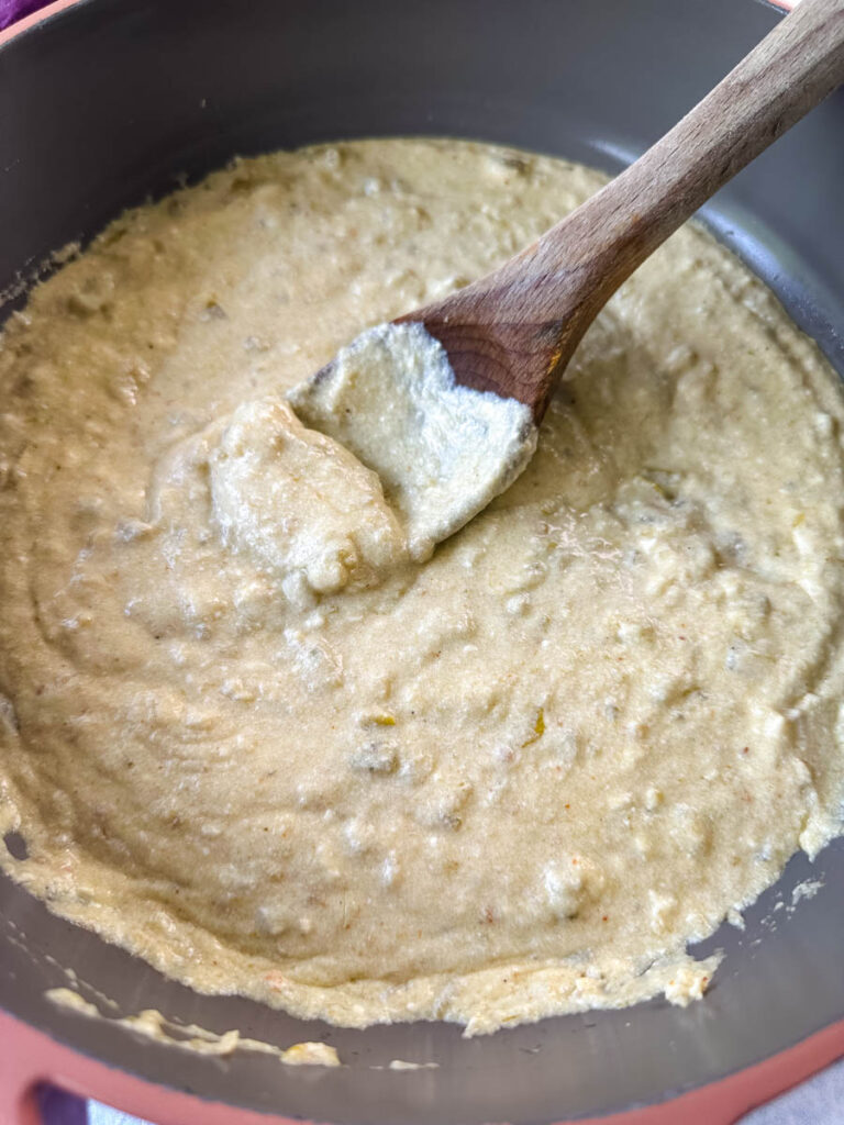 salsa verde cream sauce in a pan with a wooden spoon
