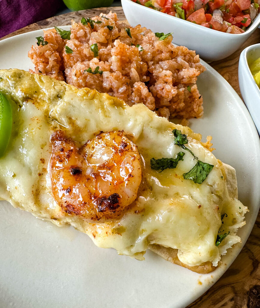 shrimp enchiladas on a plate with Spanish rice and pico de gallo