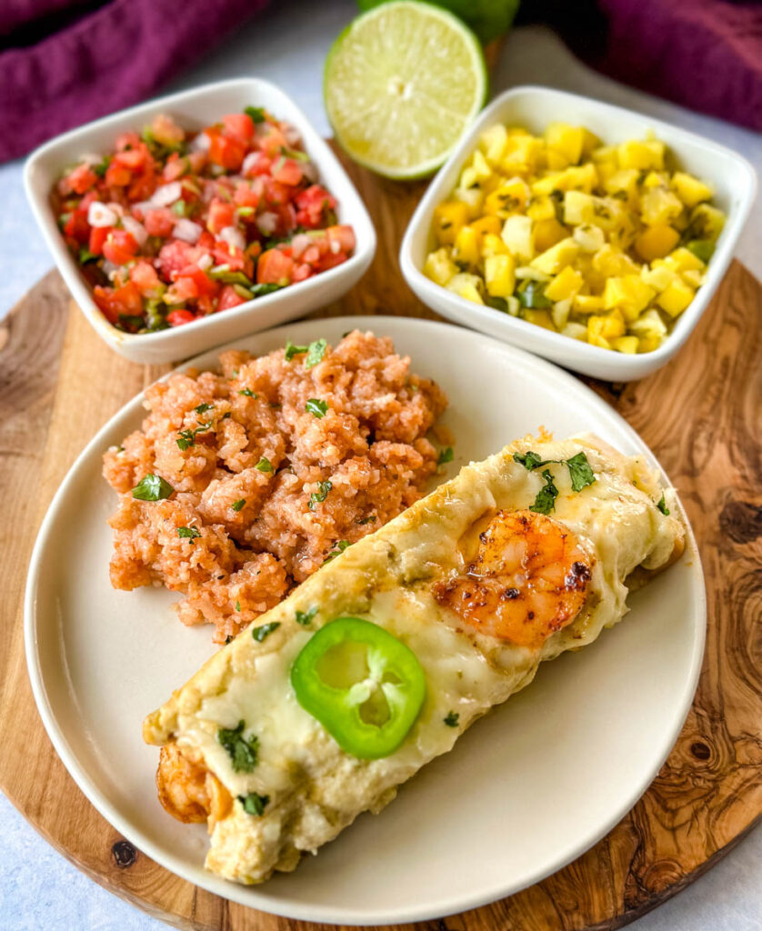 shrimp enchiladas on a plate with Spanish rice and pico de gallo