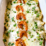 baked shrimp enchiladas in a baking dish with cilantro