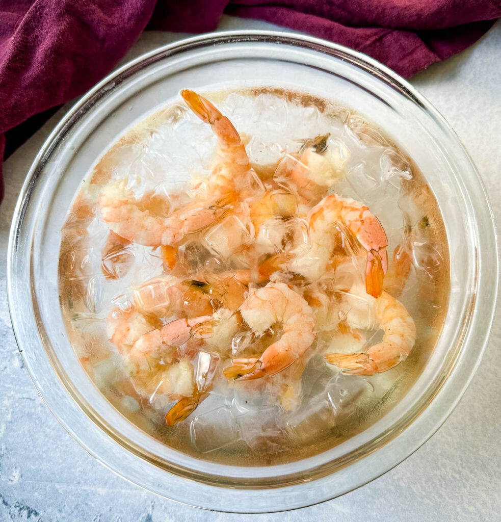 poached shrimp in a glass bowl with ice water