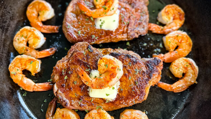 steak and shrimp with butter in a cast iron skillet
