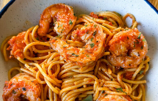 shrimp spaghetti with garlic in a white bowl with a fork